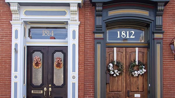 Two front doors side by side on the frontage of a pair of adjoining houses