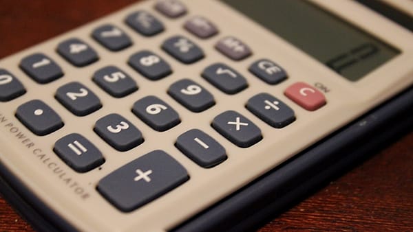 A simple pocket calculator lying on a flat surface with its keys facing up