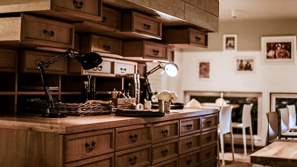 A wooden work counter fitted with rows of small drawers in a warm lit interior