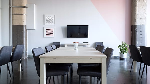 An empty meeting room with a bare table and chairs arranged neatly around it