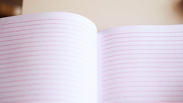 A new notebook lying open at a blank page on a plain desk surface