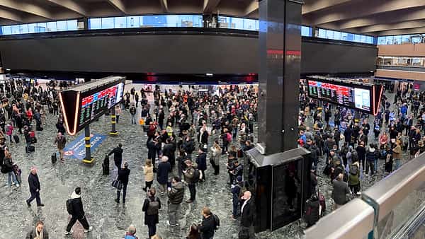 A station concourse where the overhead information screens are showing nothing at all