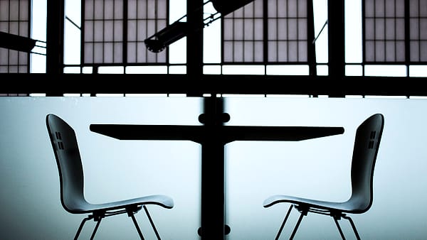 A low table with seating arranged on either side of it in a quiet room