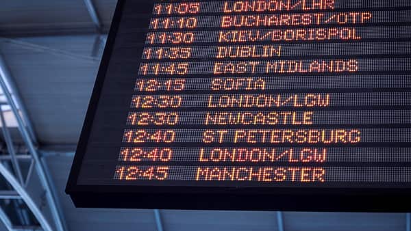 An airport arrivals and departures board showing rows of listed times and destinations