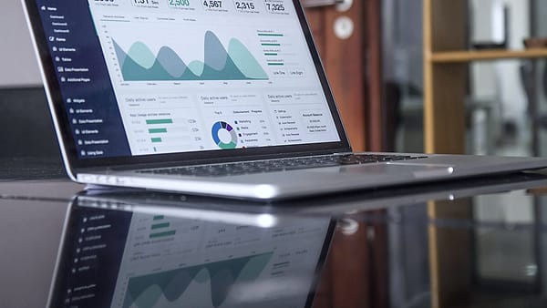 A laptop screen showing a page of statistics and charts on a desk