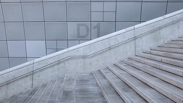 A concrete staircase turning at a landing between two flights of steps