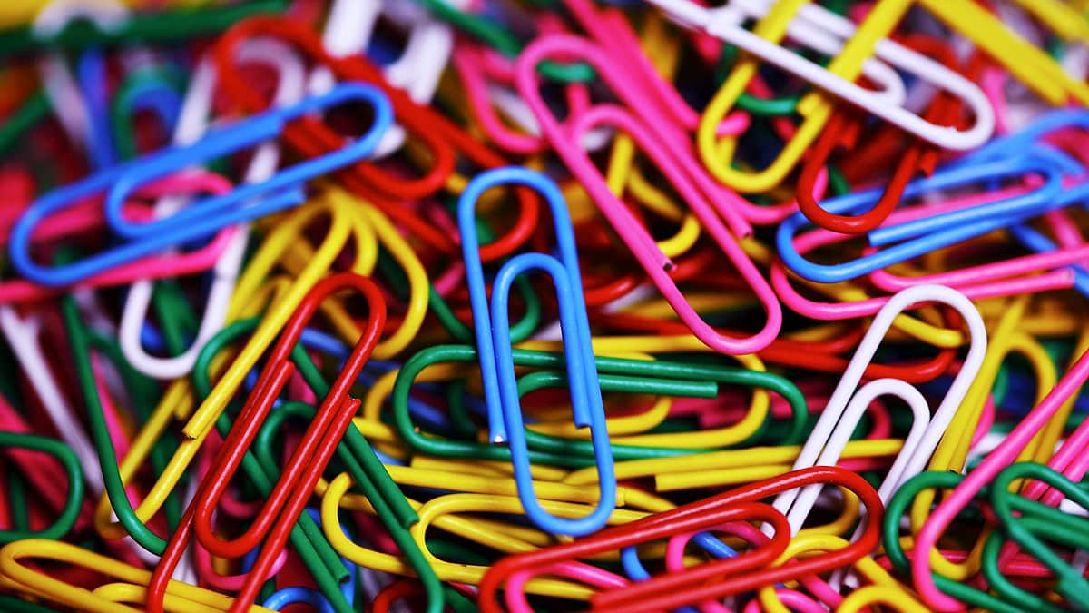 An assortment of colored paper clips scattered loosely across a surface