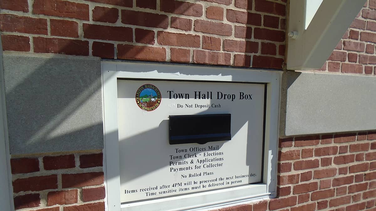 A metal deposit box set into the exterior wall of a public building