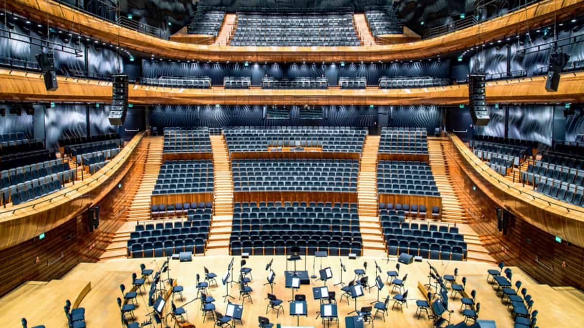 An empty concert hall with rows of unoccupied seats facing the stage