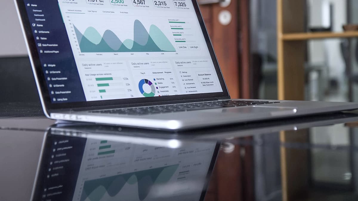 A laptop screen showing a page of statistics and charts on a desk