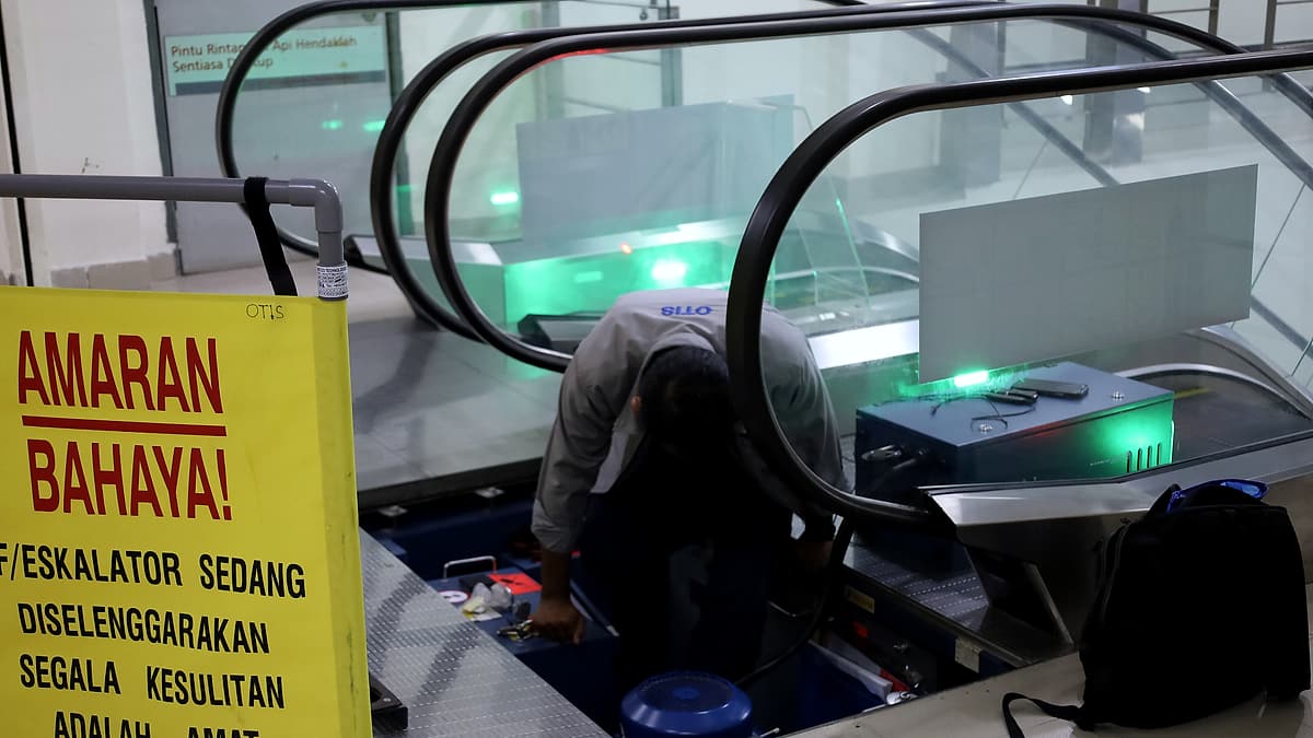 An escalator standing still with its panels open for maintenance work