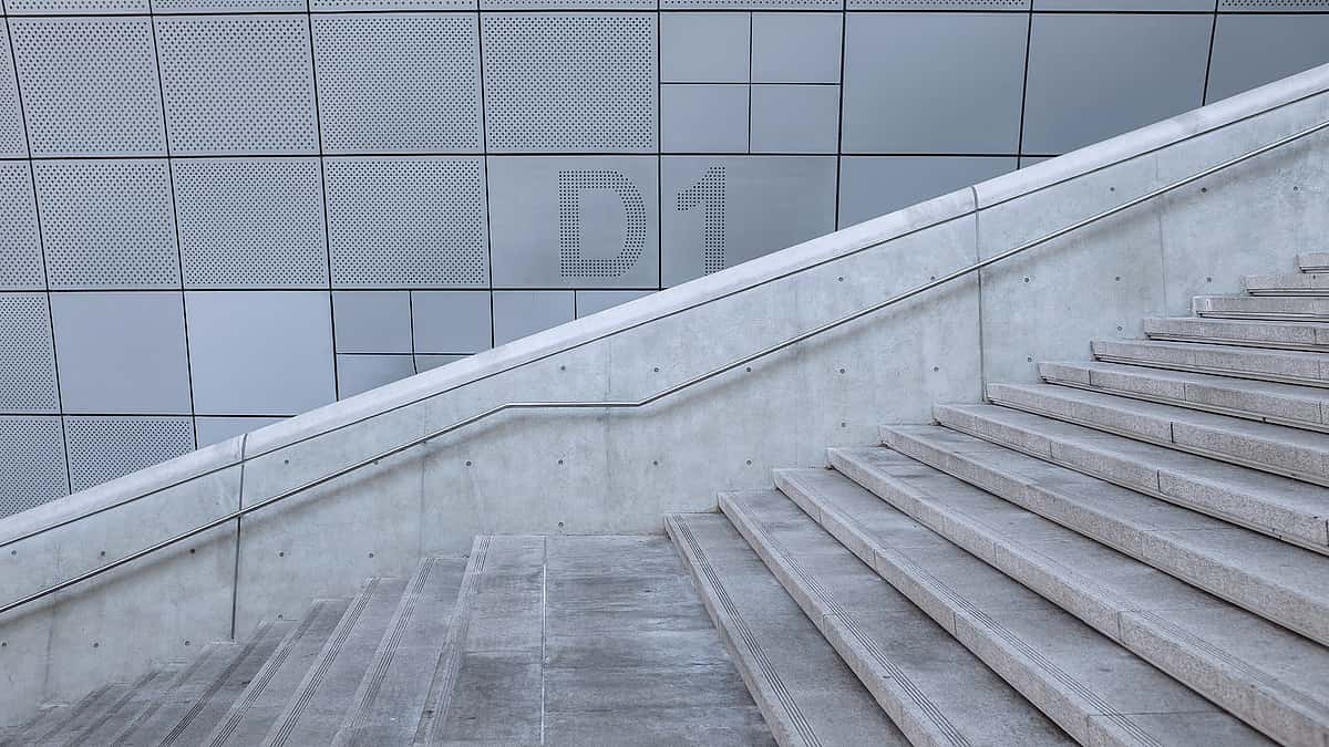 A concrete staircase turning at a landing between two flights of steps